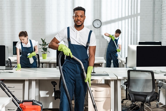 handsome african american cleaner looking at camera while standi