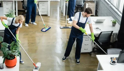 stock-photo-high-angle-view-cleaners-washing-floor-tables-office